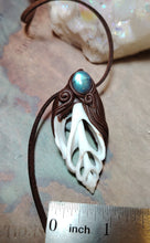 Load image into Gallery viewer, A close-up of a handmade pendant necklace featuring a dark brown leather cord, a carved white and dark brown pendant with a blue-green stone, and a metal ruler at the bottom indicating scale.